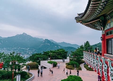 Hikers walking on a forested trail at Bugaksan Mountain in Seoul