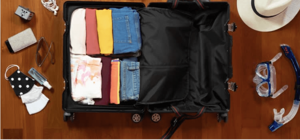 Open luggage with folded clothes and travel essentials for Seoul trip
